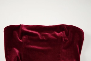 Detailed close-up of wine red velvet fabric showing smooth texture and sheen on mini dress