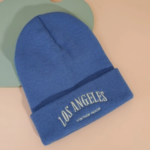 Détail du bonnet en maille bleue avec broderie blanche LOS ANGELES et VINTAGE MADE précise