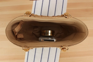 Detail view of woven straw tote bag interior showing fabric lining and zipper pocket