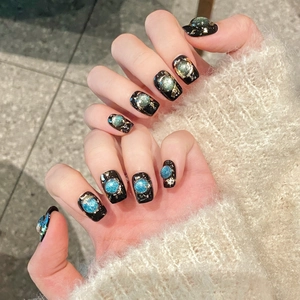 Handmade black cat-eye press-on nails with 3D opal effect and gold foil accents
