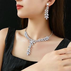 Close-up of sparkling leaf-shaped zircon necklace and earrings set on a model