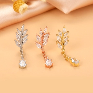 Detailed macro view of leaf-shaped ear studs in silver, rose gold, and gold finishes