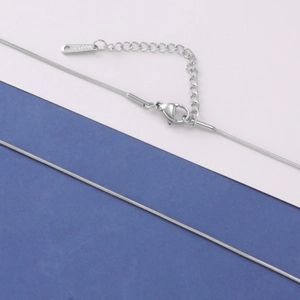 Macro detail of silver stainless steel snake chain with lobster clasp and S.STEEL tag