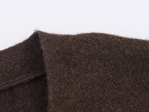 Dettaglio della trama in maglia marrone caffè con morbide fibre di lana premium