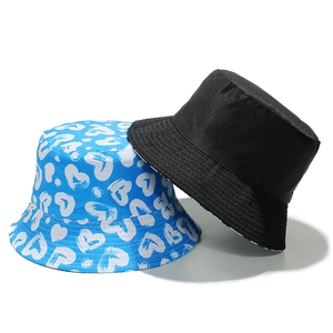 Set of blue heart print and plain black cotton bucket hats on a white background