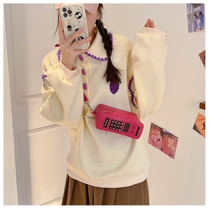 Detail of pink retro telephone shaped crossbody bag with creative keypad design