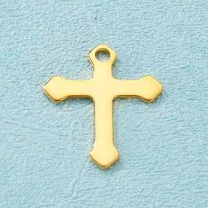 Macro shot of polished gold stainless steel cross pendant on a light blue background