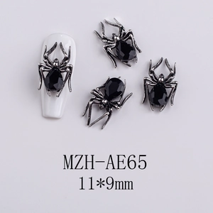 Macro detail of dark silver spider nail charms with black rhinestones for Halloween