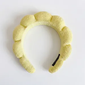 Macro shot of fluffy yellow sponge headband with soft terry cloth texture and black lining