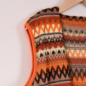 Détail du gilet en maille bohème avec motifs géométriques et bordures orange contrastées