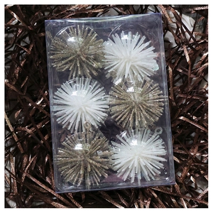 Close-up of six sparkling champagne and white starburst Christmas tree ornaments in a box