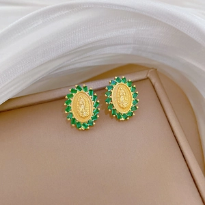Elegant gold oval portrait earrings with green rectangular stones on beige display