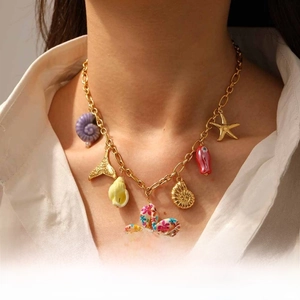 Detail of gold ocean necklace featuring purple conch, starfish and colorful floral pendants