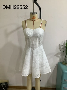 Detail of white lace dress showing heart neckline and circular hollow embroidery
