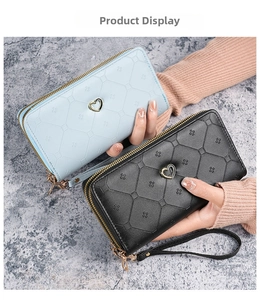 Detail of light blue and black long wallets with diamond quilt and gold heart clasps