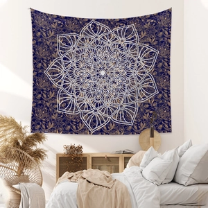 Detail of bohemian mandala tapestry featuring gold paisley patterns on dark blue fabric
