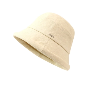 Cappello da pescatore minimalista crema con placchetta in metallo su sfondo bianco