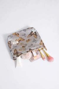 Macro detail of butterfly print makeup bag with gold zipper and satin texture