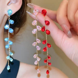 Close-up of elegant long tassel earrings featuring pear-cut crystals in multiple colors