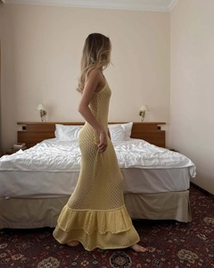 Nahaufnahme der gelben Häkelstrick-Textur und der gestuften Rüschen am Maxikleid-Saum