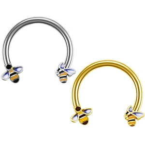 Detail of bee-shaped horseshoe rings in gold and silver finish with enamel details