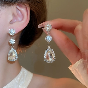 Close-up of sparkling teardrop rhinestone earrings in vintage silver-tone finish