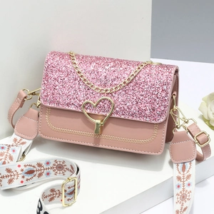 Elegant pink handbag with sequin flap, heart buckle, and gold chain handle in studio view