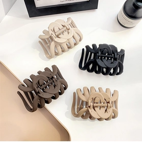 Flat lay of large matte octopus hair claws in beige, black, dark brown, and khaki