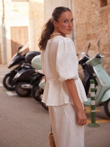 Detail of white cotton summer set with puff sleeve shirt and matching long skirt in sunlight