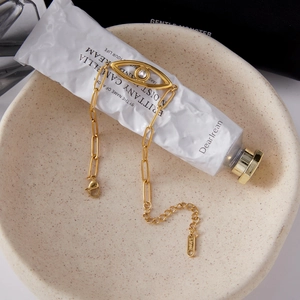 Detail of 18K gold stainless steel bracelet featuring zircon evil eye charm