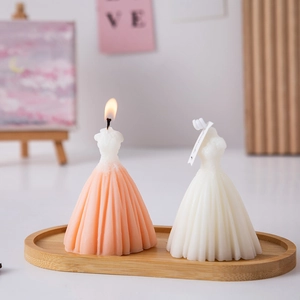 Detail of lit pink and white wedding dress scented candles on a wooden tray