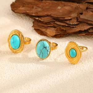 Detailed view of three vintage gold rings featuring green turquoise oval stones