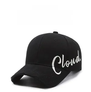 Detail of white Cloud embroidery and distressed brim on a black cotton baseball cap