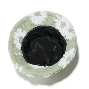 Macro detail of plush teddy fleece bucket hat with white flower patterns and satin lining