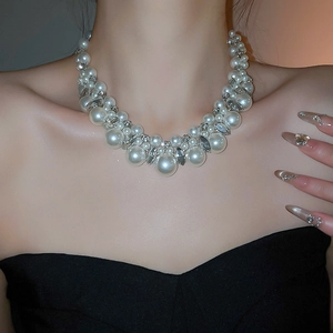 Close-up of sparkling rhinestone and pearl beaded choker necklace on a model's neck