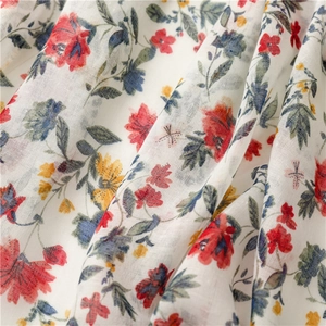 Macro detail of the white floral fabric texture with red and yellow flowers and soft drapes