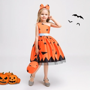 Detail of girls pumpkin dress with matching bow headband and festive handbag