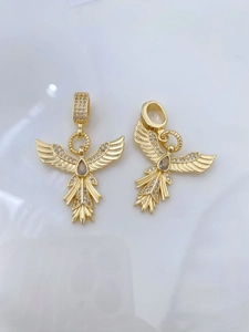 Detailed macro view of golden phoenix pendants with sparkling crystals and drop gemstone