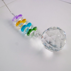 Macro detail of multi-faceted crystal ball with rainbow beads on silver chain
