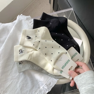 Detail of embroidered cotton socks in cream, black and grey with premium rib cuffs