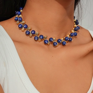 Detail of blue lapis beads and golden leaf charms with diamonds on a choker necklace