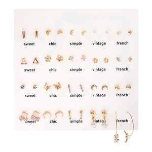 Macro shot of 15 pairs heart and pearl stud earrings set on a white sweet chic display card