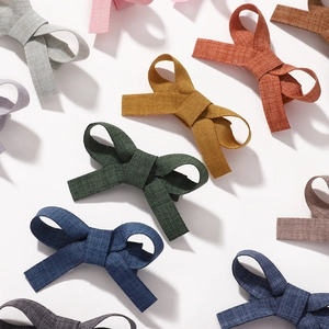 Handmade cotton linen bow hair clips for girls in various solid colors on white background