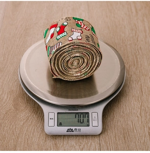 Close-up of burlap Christmas ribbon with Merry Christmas text and stocking patterns