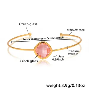 Detail of a gold open bangle with a square pink Czech glass inlay and steel frame