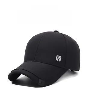 Detail of black cotton baseball cap showing silver logo plaque and twill fabric texture