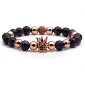 Detailed shot of purple tiger eye stone beads and rose gold crown charm on elastic bracelet