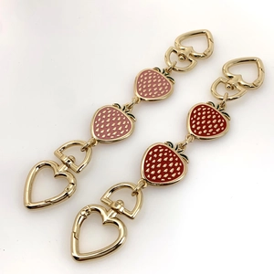 Pink and red strawberry bag charms with heart-shaped golden spring clasps