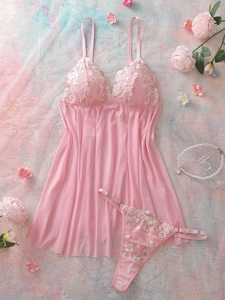 Détail d'un ensemble de lingerie en résille rose avec broderie florale et roses