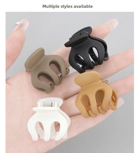 Detail view of matte pumpkin hair clips in black, caramel, latte, and cream colors